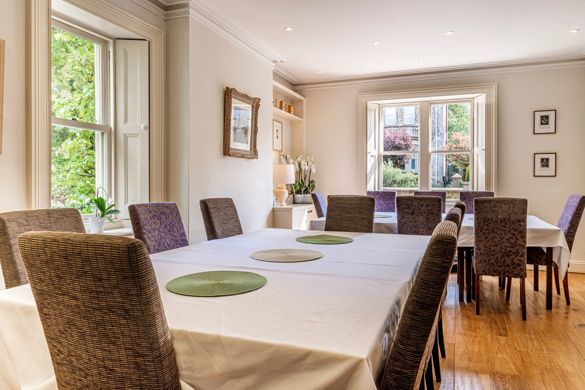 Dining tables and upholstered chairs beside the windows at Lorne House