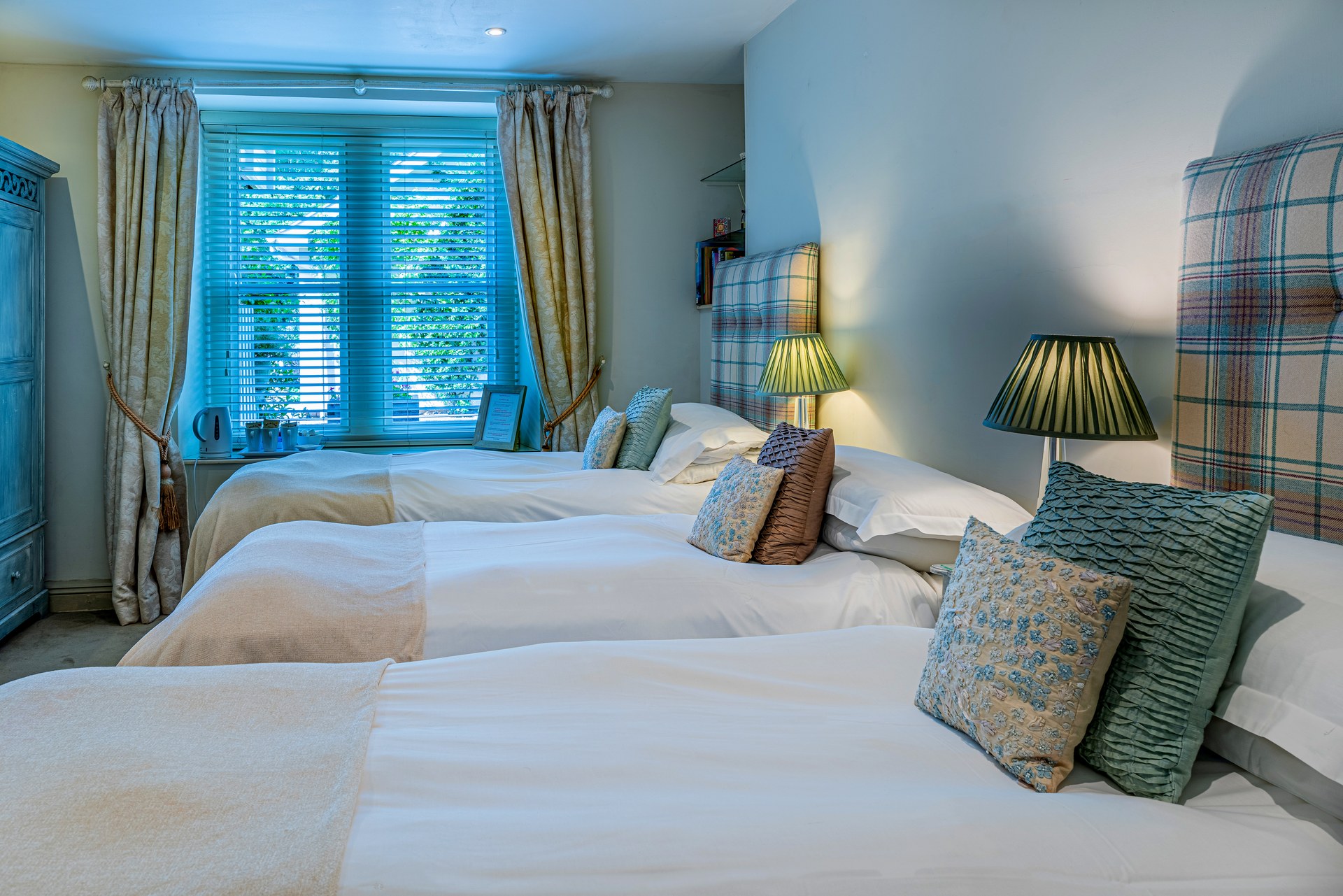 Two single beds with patterned headboards in a Lorne House bedroom